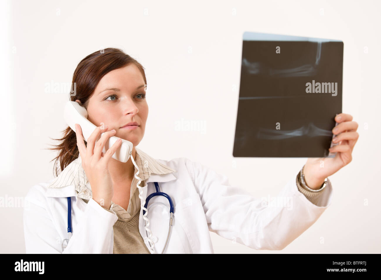 Ärztin mit Röntgen- und Telefon Check-Ergebnis Stockfoto