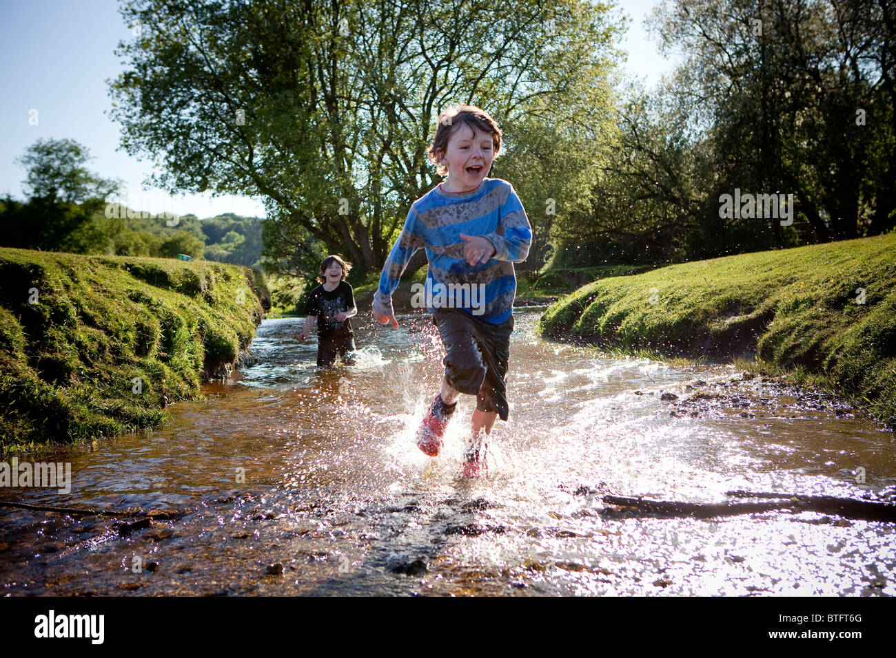 Zwei jungen im Stream laufen Stockfoto