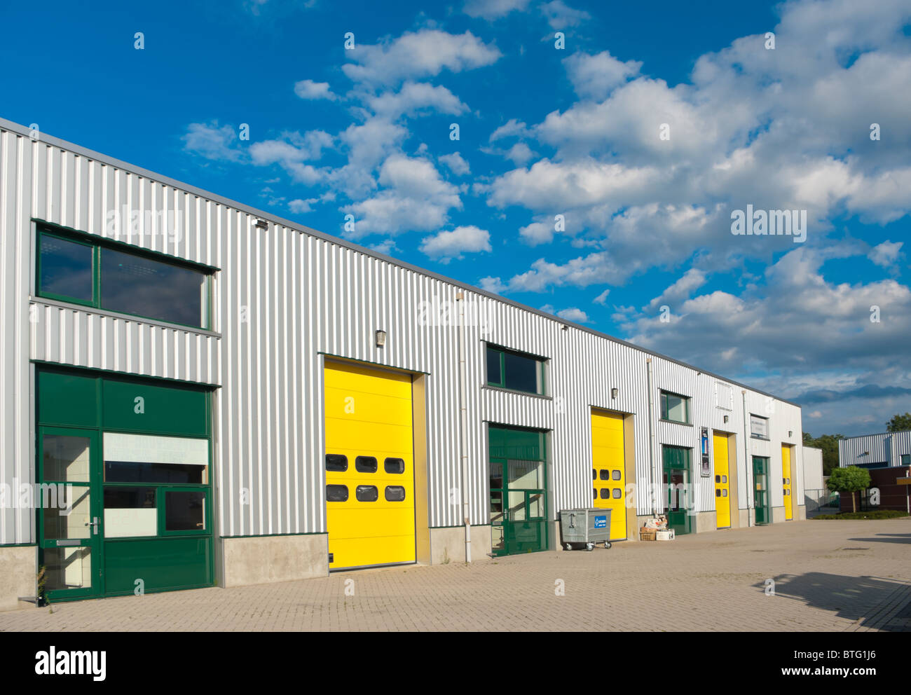 Industriehalle mit grünen und gelben Rolltore Stockfoto