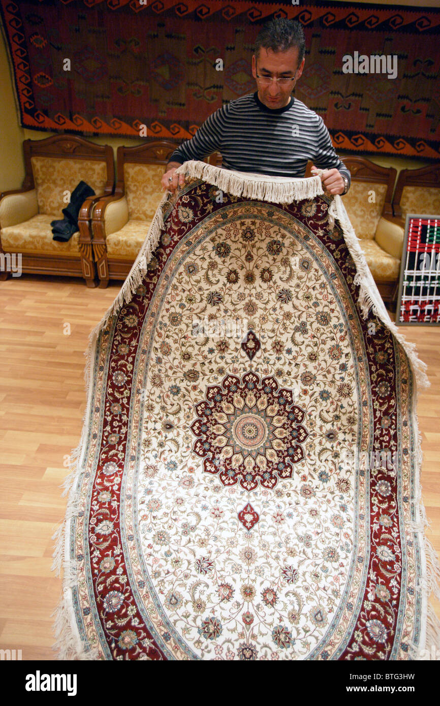 Herr Mehmet Polat anzeigen eine Hand Seide Teppich aus Konya hergestellt.  Bosporus Carpet Weavers Coop, Istanbul, Türkei. PR und Herr Stockfotografie  - Alamy
