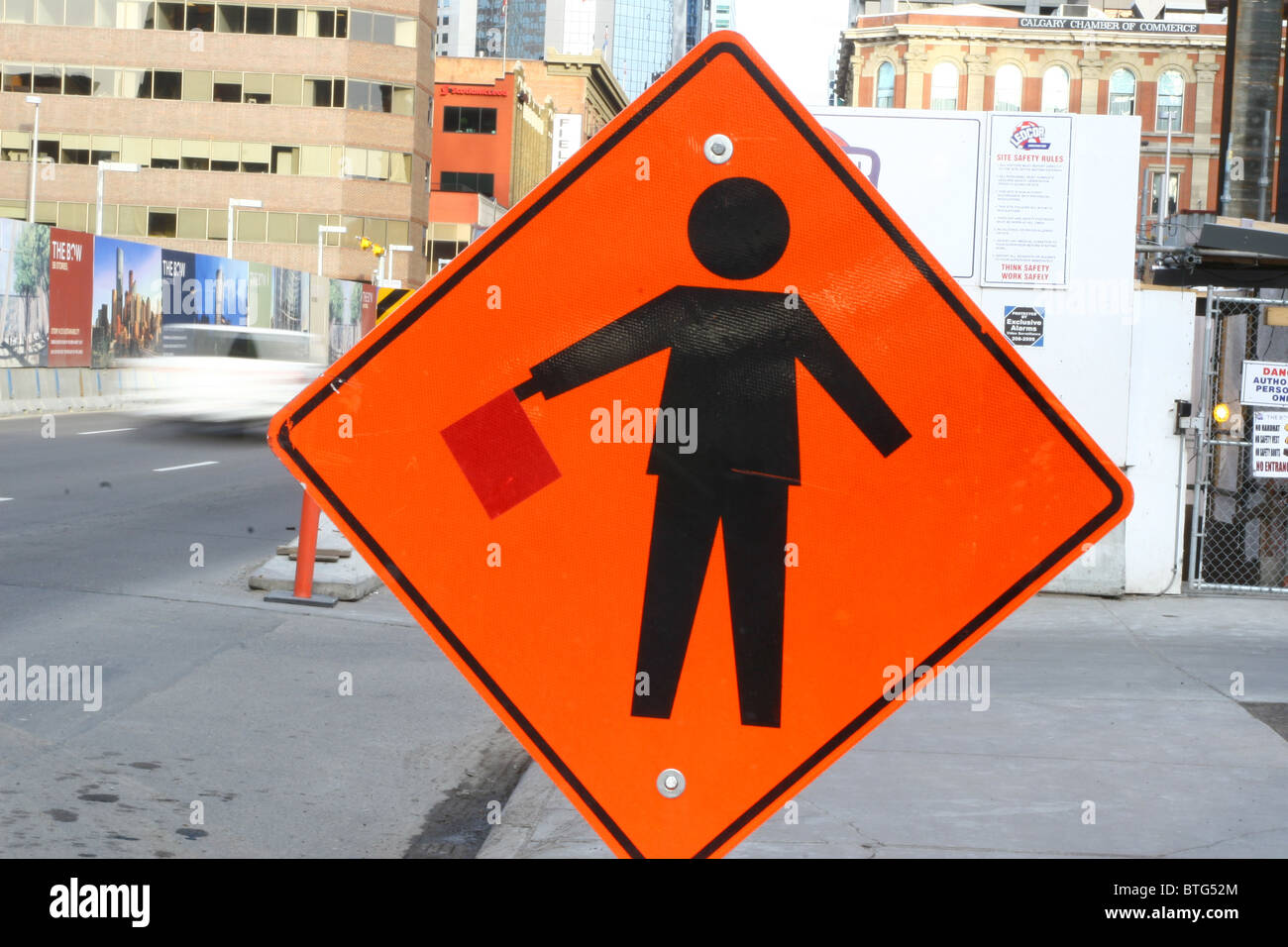 Orange Flagman Warnschild an einer Baustelle in der Innenstadt von Calgary, Alberta, Kanada Stockfoto