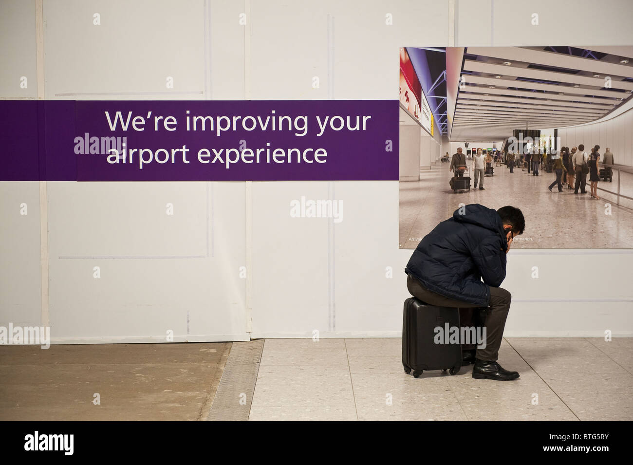 Ein verzweifelter Passagier, der am Terminal 4, Heathrow Airport, London, Großbritannien, Verspätung hatte Stockfoto
