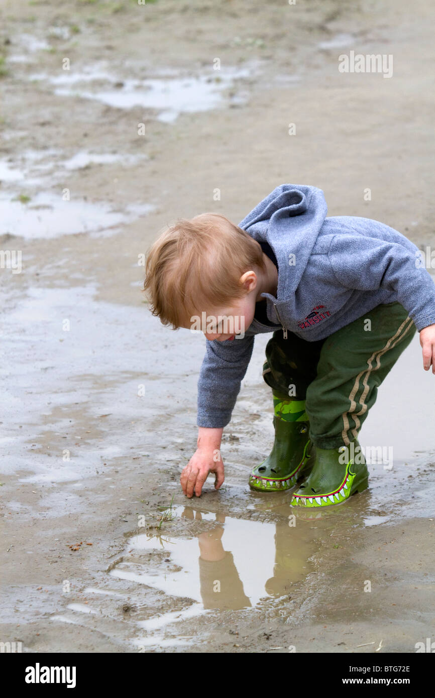 Kleiner Junge spielt in Pfützen am Skagit Valley, Washington, USA. Stockfoto