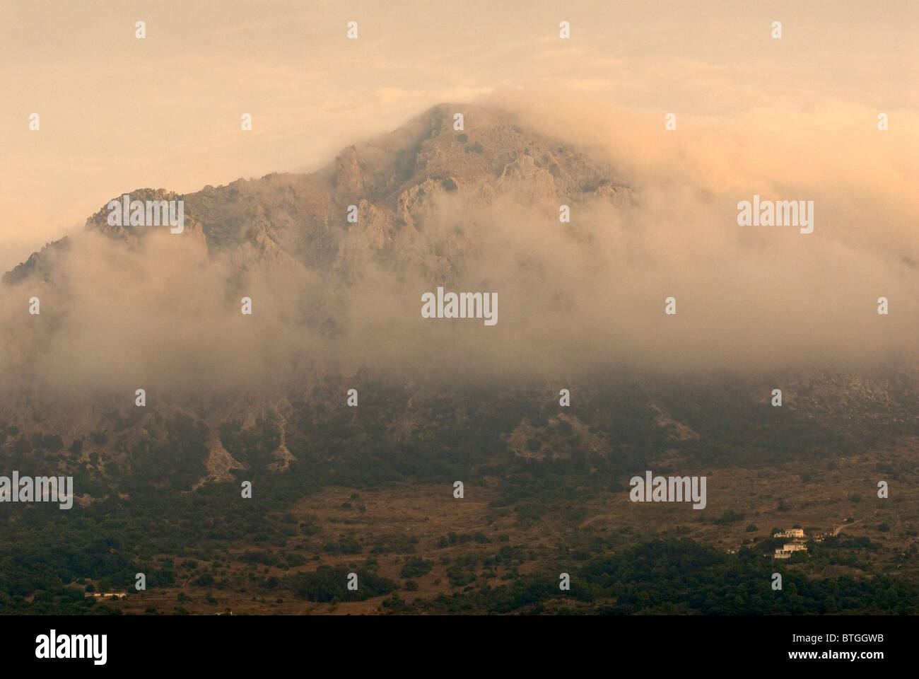 Andalusische Gebirge teilweise in Wolken gehüllt Häuser im Vordergrund Stockfoto