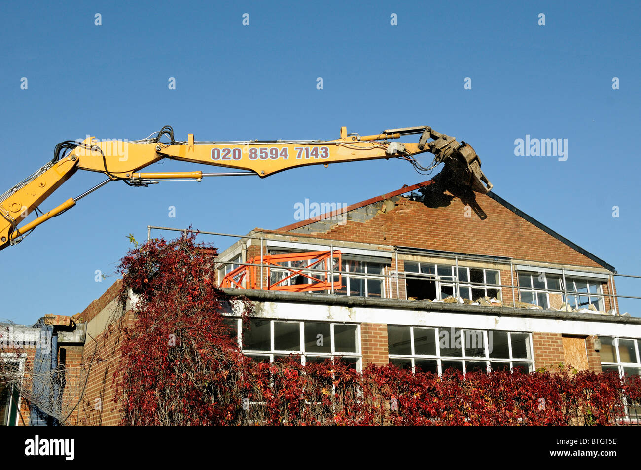 Baggerarm mit mehreren Prozessoren, Pulverisator, Abbruch Scheren befestigt gegen Abriss eines Gebäudes in Holloway Himmel gesehen Stockfoto