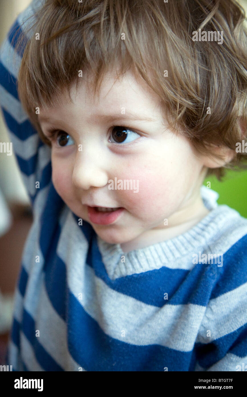 22 Monate baby Boy mit gestreiften blau-grauen Pullover Stockfoto