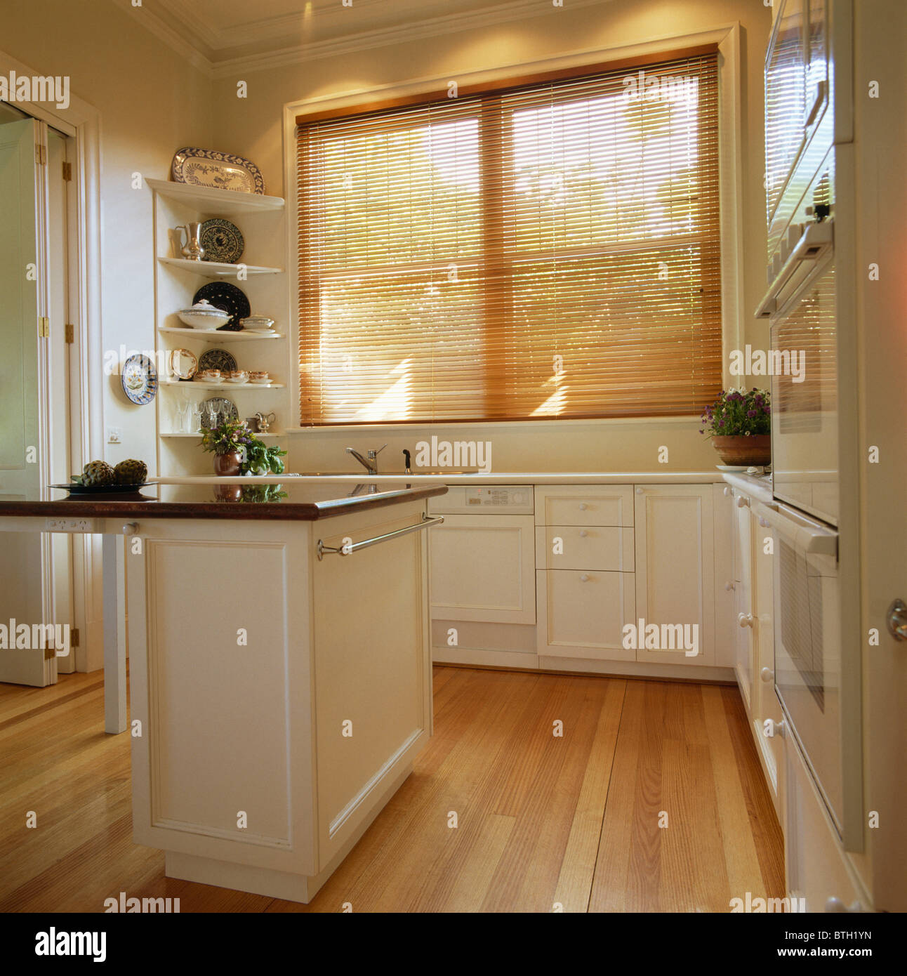 Lattenrost blind und Holz Holzboden in modernen weißen Küche mit Insel Stockfoto