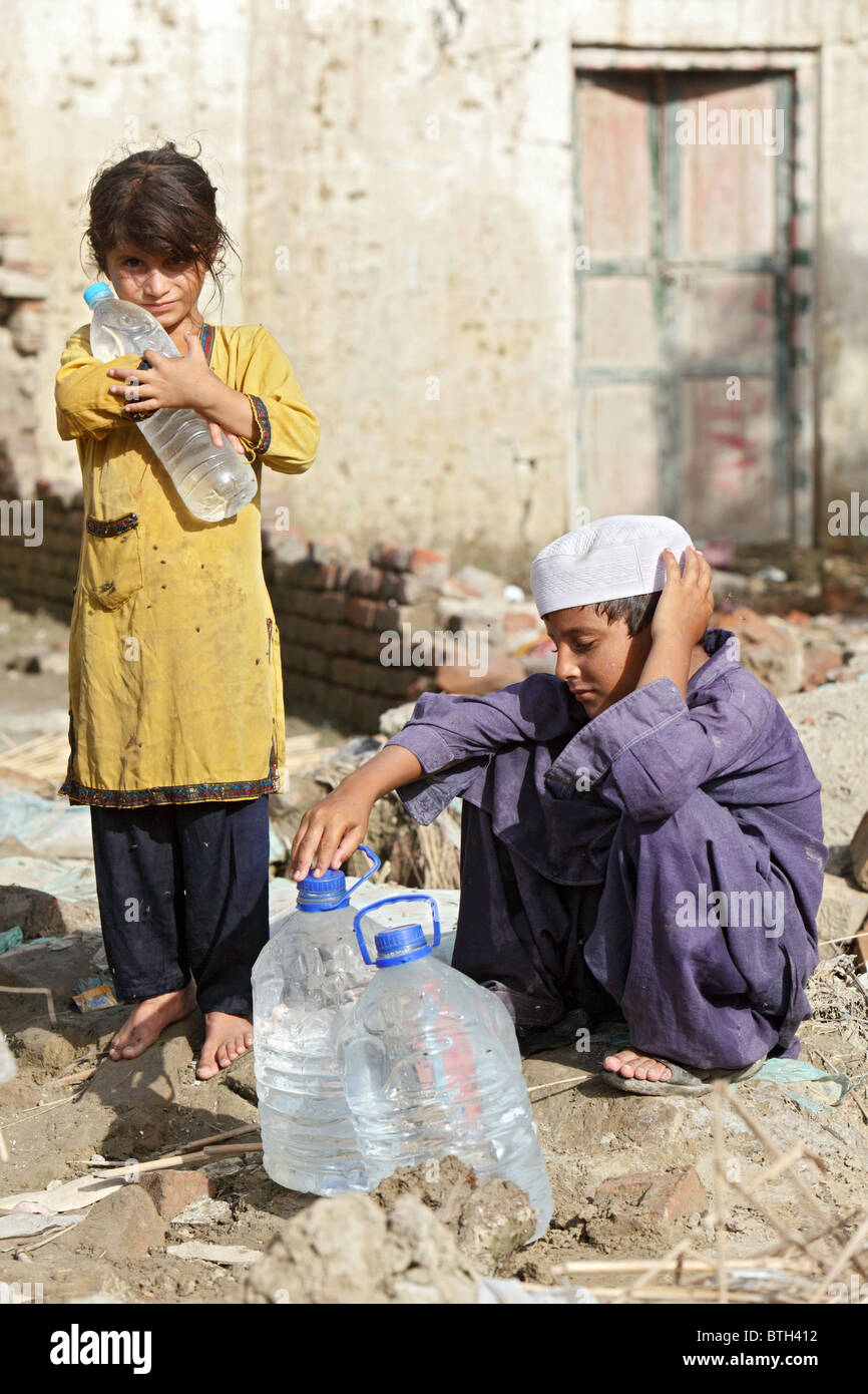 Ein Mädchen mit einer Flasche Wasser auf dem Arm, Nowshera, Pakistan Stockfoto