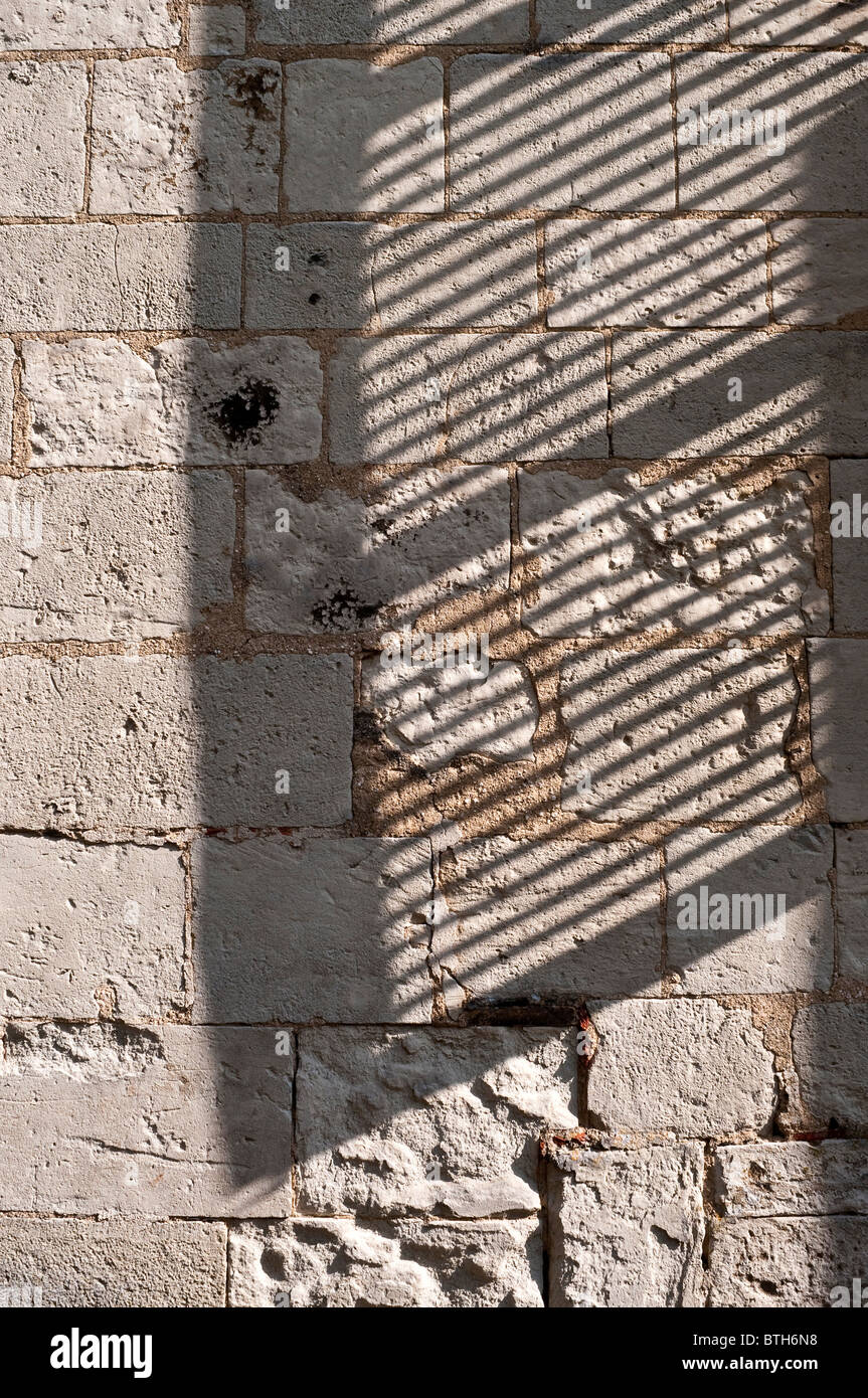 Schatten Sie auf der Steinmauer aus Lamellen Fenster Rollladen - Frankreich. Stockfoto