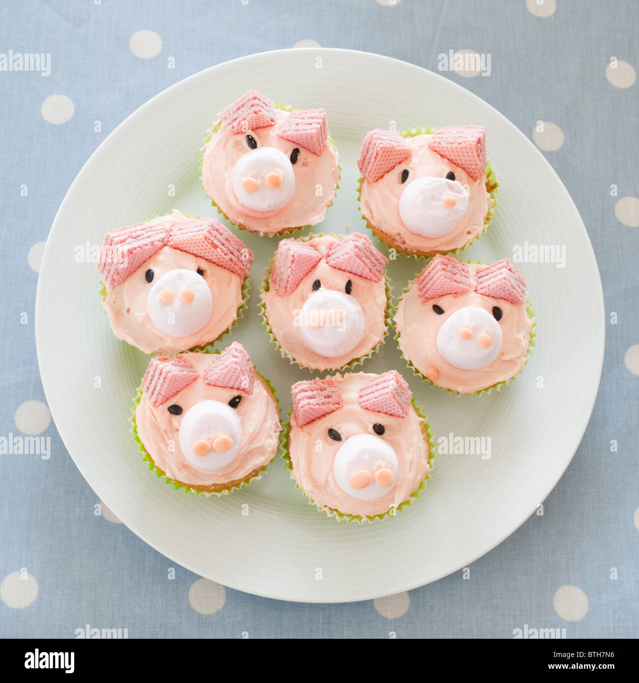 Ein Teller mit rosa Schwein iced hausgemachten Brötchen für eine Kinder-Geburtstags-party Stockfoto