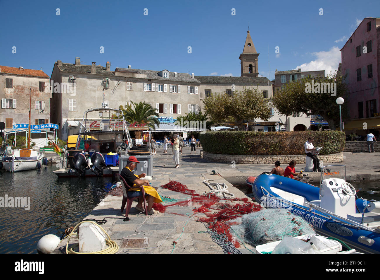 Fischer ausbessern Netze am St Florent Stockfoto