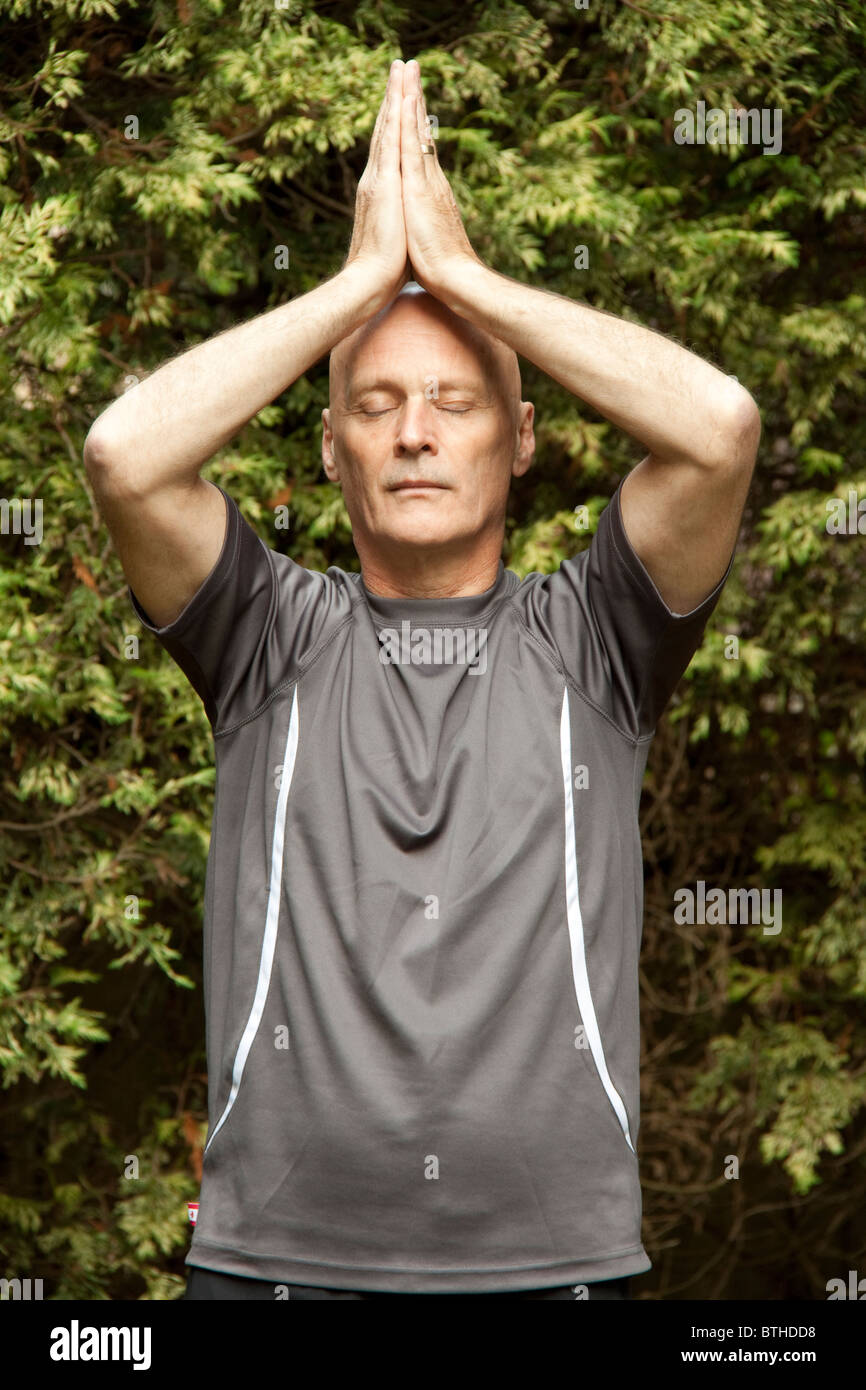 Schweren, glatzköpfiger Mann praktizieren Yoga im freien Stockfoto