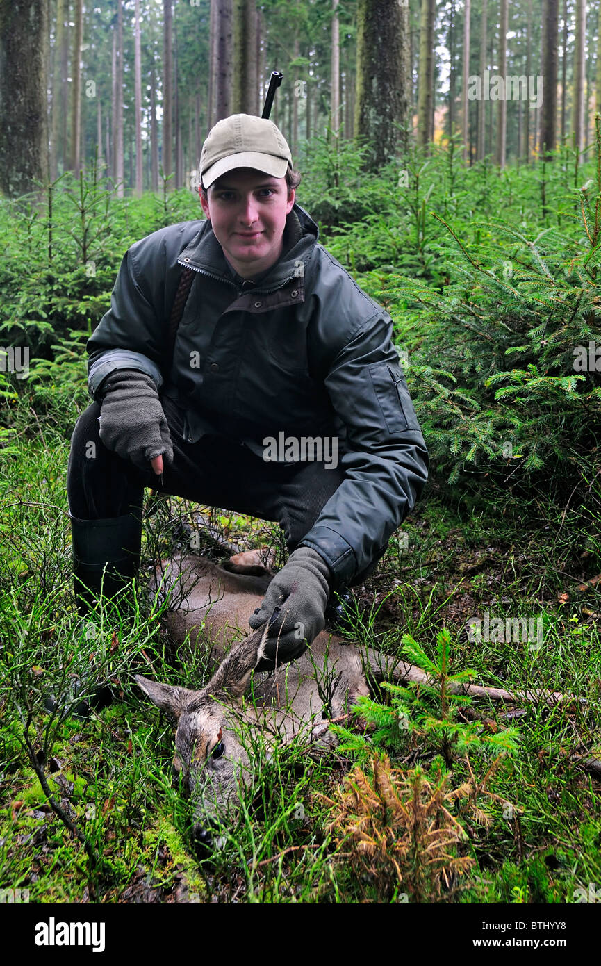 Jäger mit Schuss Reh (Capreolus Capreolus) im Wald in den Ardennen, Belgien Stockfoto