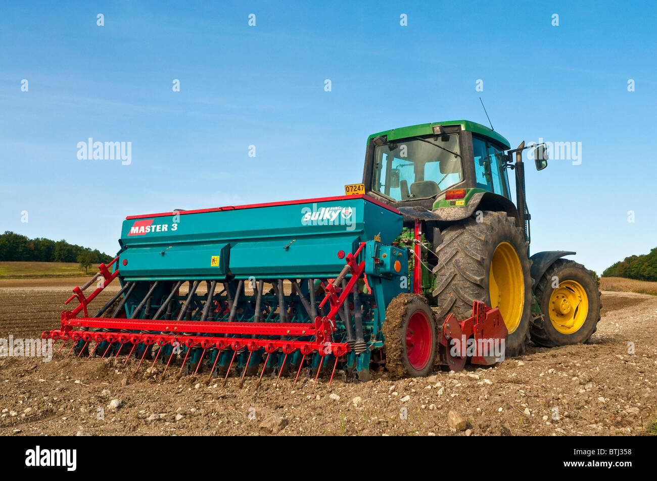 John Deere Traktor mit Sulky Master 3 Drillmaschine - Frankreich. Stockfoto