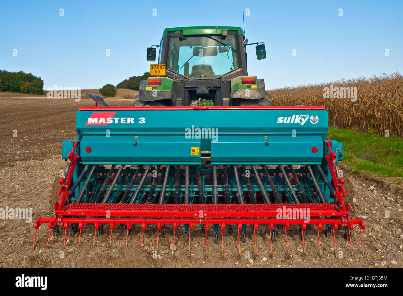 John Deere Traktor mit Sulky Master 3 Drillmaschine - Frankreich. Stockfoto
