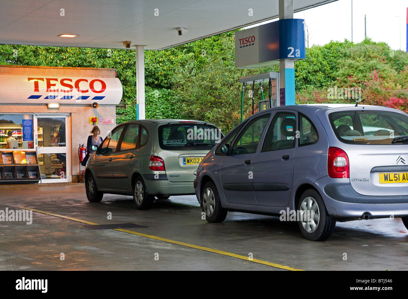 Autos warten für Treibstoff an der Tankstelle ein Tesco, uk Stockfoto