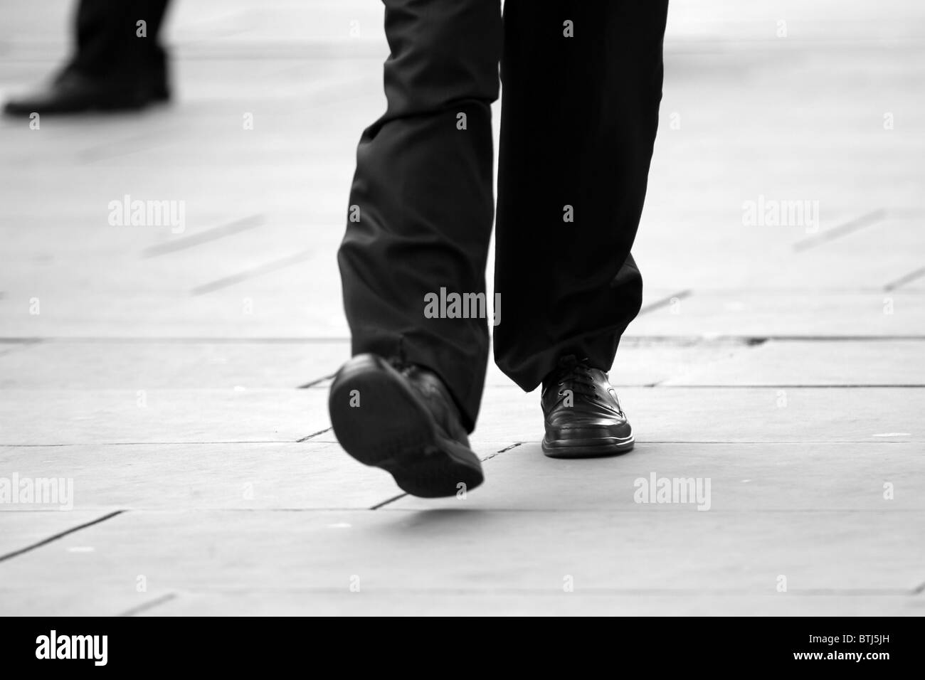 Tageslicht schwarz weiße Füße Schuhe immer zu spät zur Arbeit für die Fortbewegung Arbeitsleben Tretmühle Mäntel Tücher Lifestyle London City Stockfoto