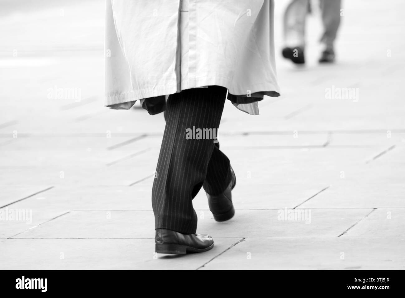 Tageslicht schwarz weiße Füße Schuhe immer zu spät zur Arbeit für die Fortbewegung Arbeitsleben Tretmühle Mäntel Tücher Lifestyle London City Stockfoto