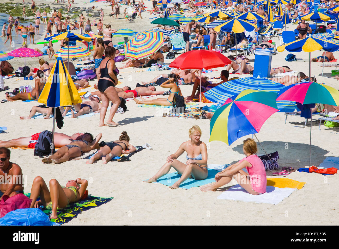 Belebten Strand mit Sonnenschirmen und viele Menschen Stockfoto