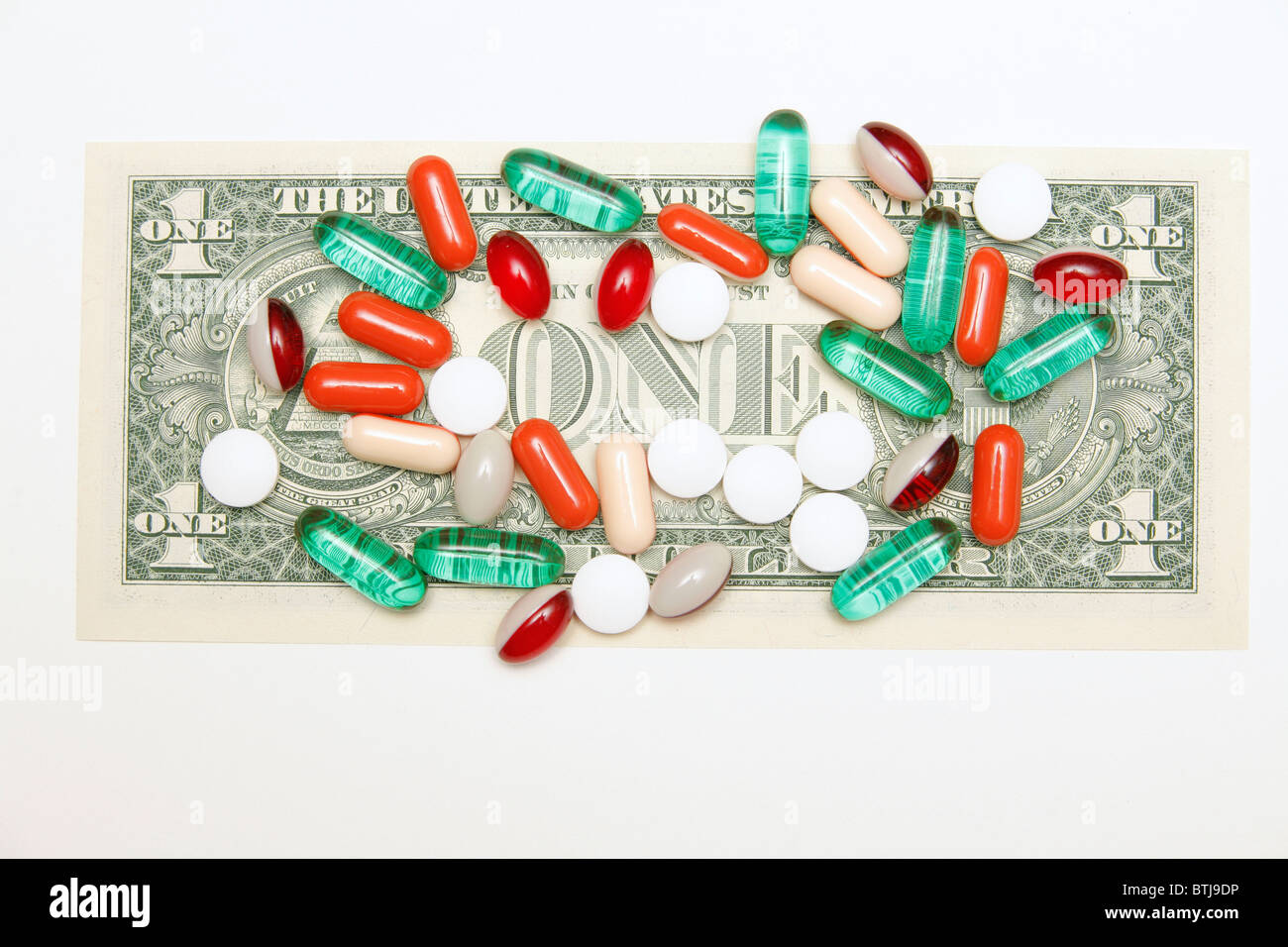 Medikamente Pillen, Tabletten und Kapseln auf US-Dollar-Schein auf grauem Hintergrund Stockfoto