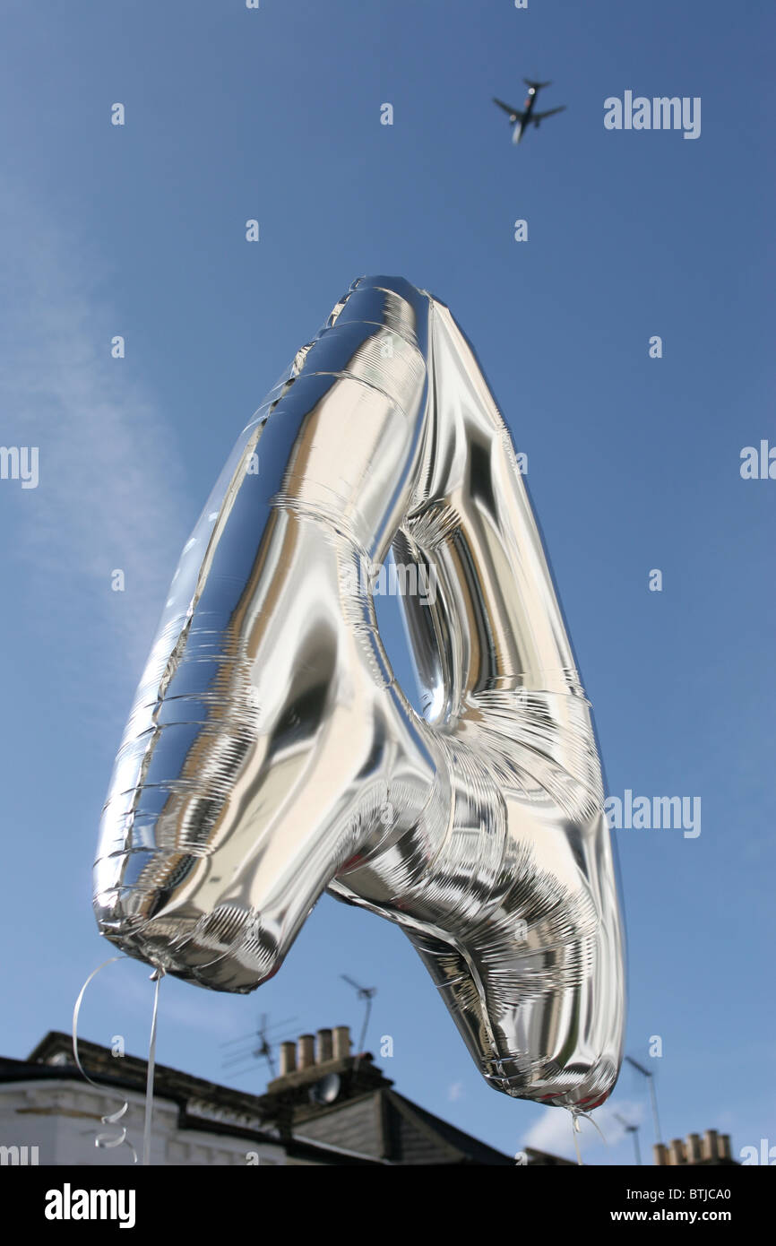 Der Buchstabe A gegen den Himmel mit einem Flugzeug im Hintergrund Stockfoto