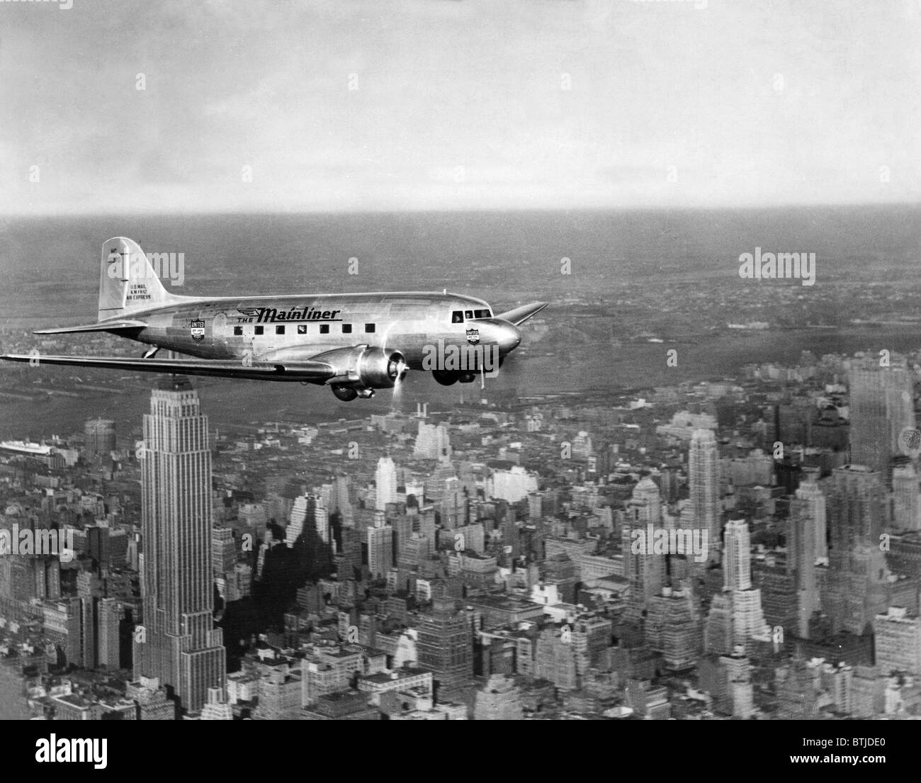 Ein Flugzeug der United Airlines fliegt über Manhattan, 1937. Höflichkeit: CSU Archive/Everett Collection Stockfoto