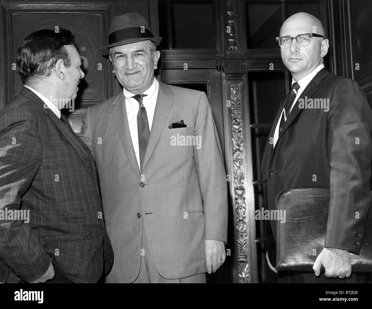 NEW YORK: Lange fehlt Mafia Führer Joseph (Joe Bananas) Bonanno (Mitte) hält UPI Reporter Robert Evans auf Schritte sprechen o Stockfoto