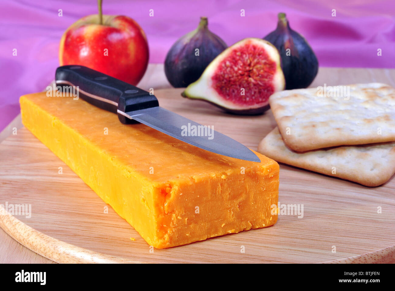 Holz-Board mit einigen Bio Cheddar-Käse Stockfoto