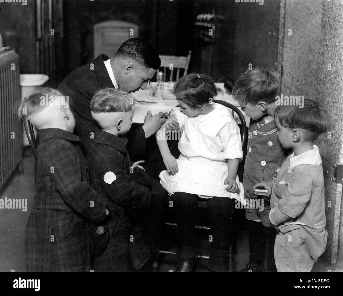 Kinder erhalten Impfungen von Dr. John Davies, 30er Jahre. Stockfoto