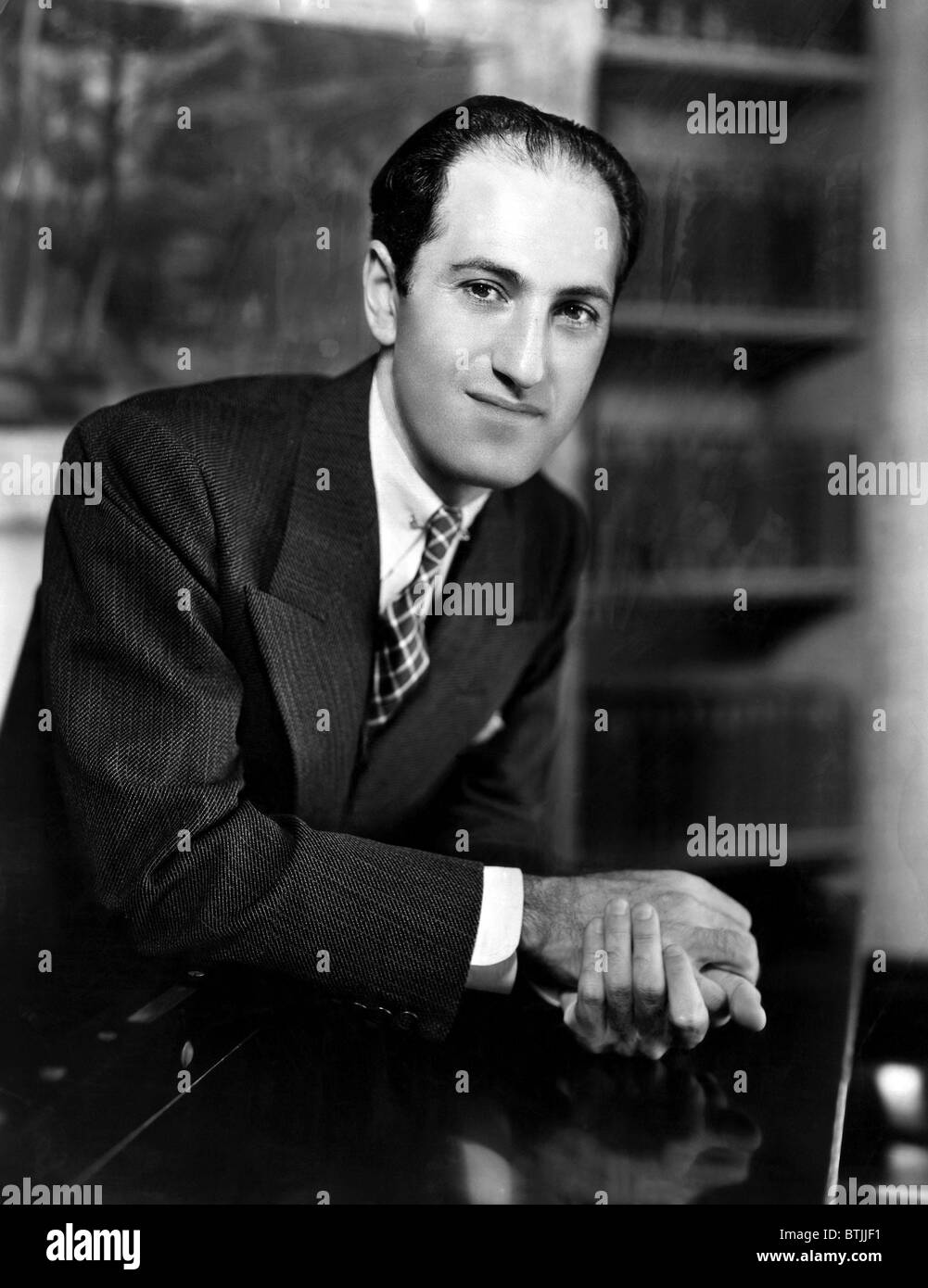 Komponist George Gershwin am Klavier in seinem New Yorker Apartment. ca. 1930er Jahre. Höflichkeit: CSU Archive/Everett Collection. Stockfoto