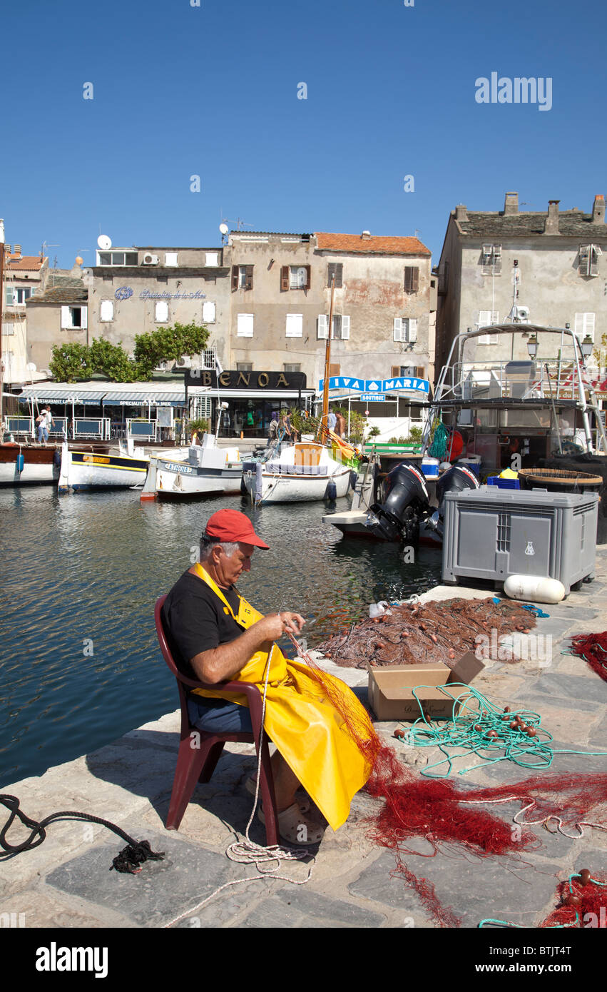 Fischer ausbessern Netze am St Florent Stockfoto