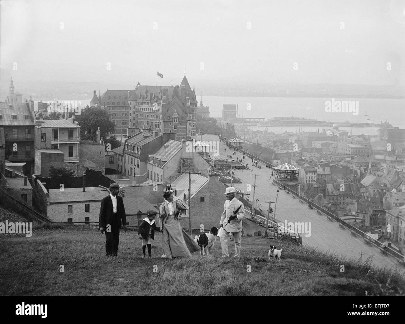 Eine Familie geht auf den Höhen von Quebec City. Le Château Frontenac im Hintergrund ist noch das führende Quebec Stadt-Wahrzeichen. Stockfoto