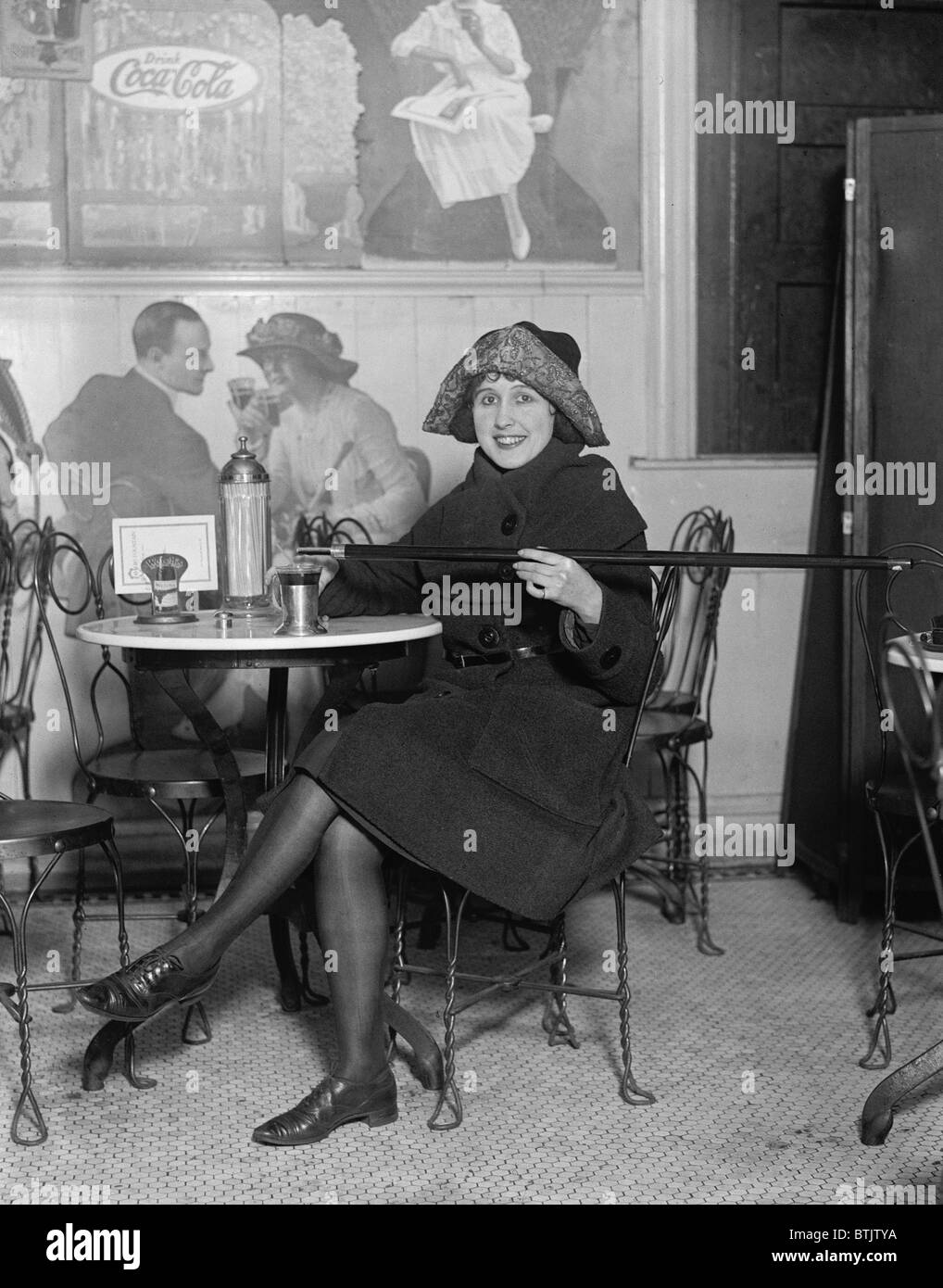 Während der Prohibition stärkt eine junge Frau ihr Getränk mit alkoholischen gegossen aus einem Spazierstock im Jahr 1922. Stockfoto