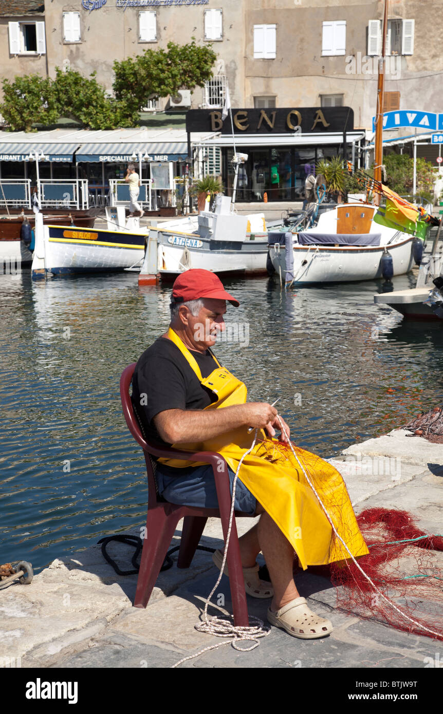 Fischer ausbessern Netze am St Florent Stockfoto