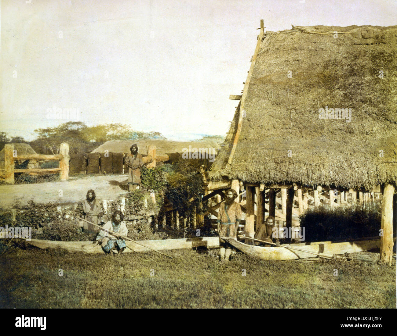 Vier Männer der Ainu mit zwei Booten von einem Strohdach, aufbauend auf der Insel Hokkiado, Japan, um 1890-1900. Stockfoto