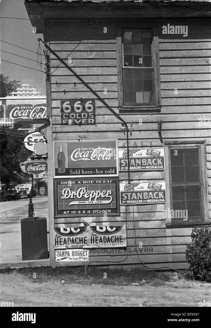 Seite eines Ladens, Werbeschilder, einschließlich 666 Erkältungsmittel, Dr. Pepper, Coca-Cola, Esso Benzin, Halifax, North Carolina, Foto von John Vachon, April 1938 zeigt. Stockfoto