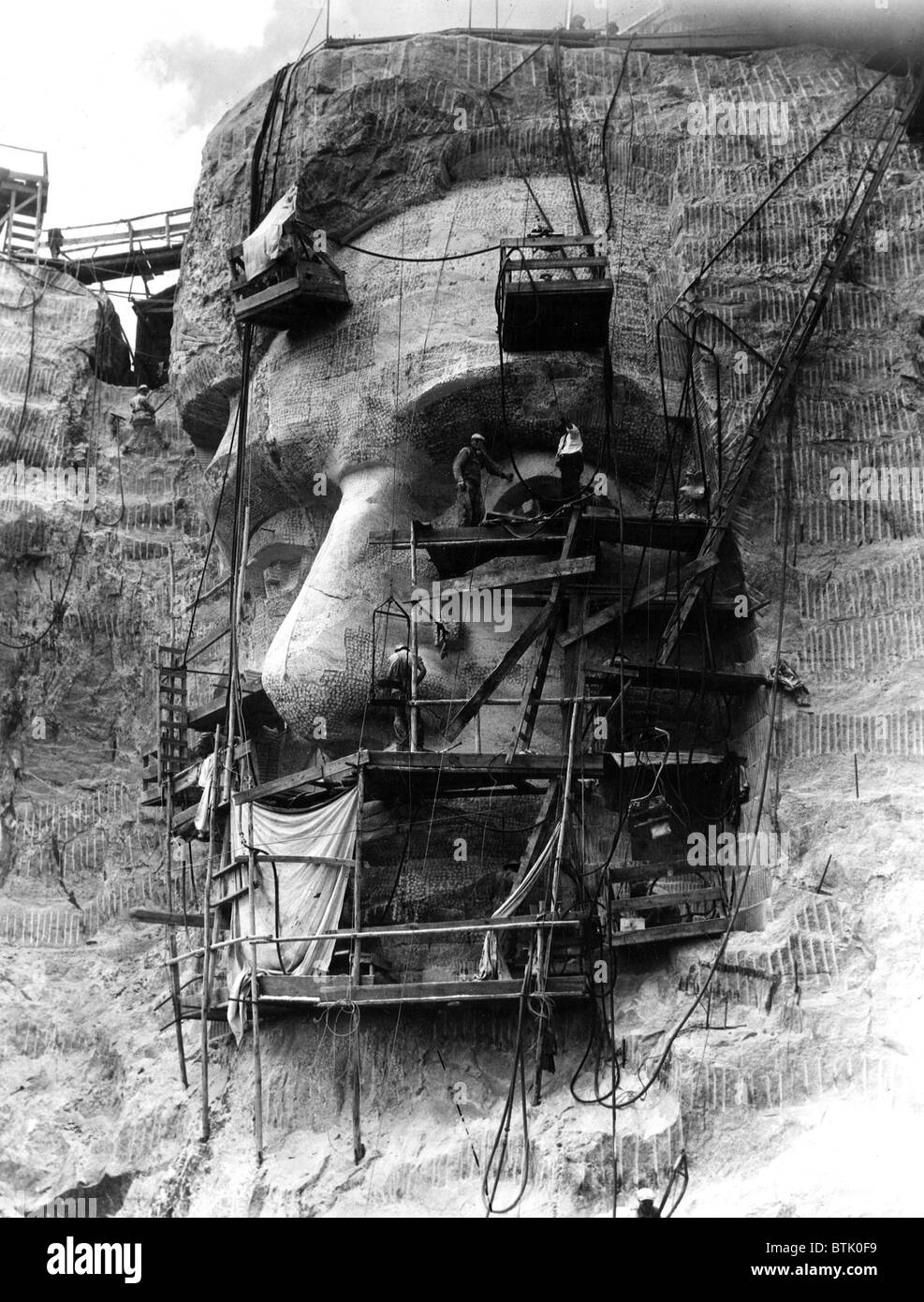 MOUNT RUSHMORE, schnitzen Arbeitnehmer unter der Leitung von Bildhauer Gutzon Borglum Kopf von Abraham Lincoln. Kopf ist Granit und Messung Stockfoto