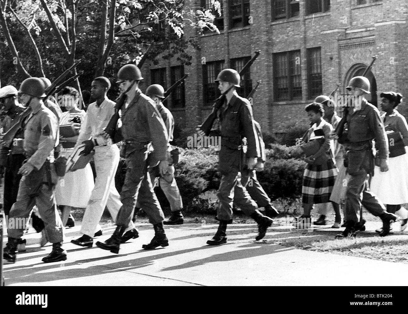 EV1815 - Daisy Bates (Blick in die Kamera auf der linken Seite) und der National Guard führt neun afroamerikanische Studenten in einer All- Stockfoto