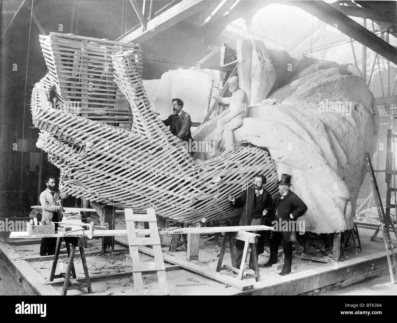 Frédéric-Auguste Bartholdi (1834-1904), der französische Schöpfer der Statue of Liberty, erklärt die innere Konstruktion des Abschnitts Hand der Statue eines Besuchers. Stockfoto
