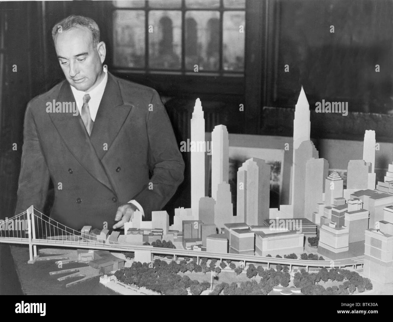 New York City Park Kommissar Robert Moses (1888 – 1981) mit Modell der vorgeschlagenen Batterie-Brücke im Jahr 1939. Während das Moses-Projekt nicht, in den nächsten vierzig Jahren gebaut wurde verwandelte er New York City mit Stadtplanung, Straßenbau und monumentalen Bauten. Stockfoto