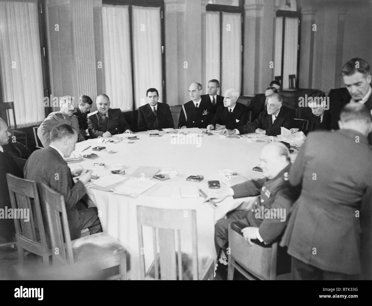 Präsident Franklin D. Roosevelt, Premierminister Winston Churchill und Marschall Joseph Stalin sind mit anderen rund um den Konferenztisch in Jalta, Krim, in der Sowjetunion gezeigt. Stockfoto