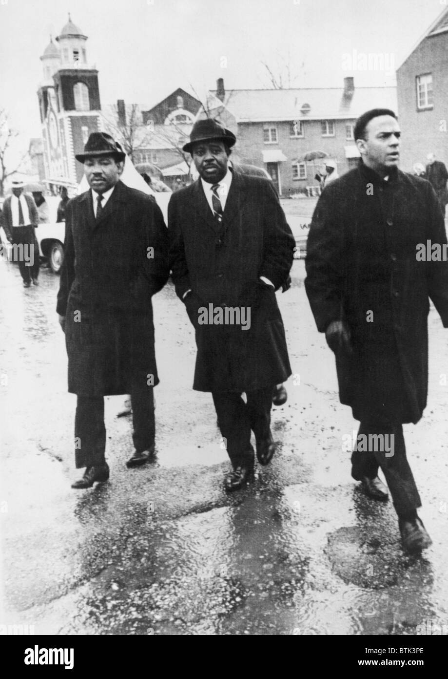 Führen Sie Martin Luther King, Jr. mit Ralph Abernethy und Andrew Young, eine Gruppe von Afro-Amerikaner in den Regen zu registrieren, um im Dallas County Courthouse in Selma, Alabama zu stimmen. 1. März 1965. Stockfoto