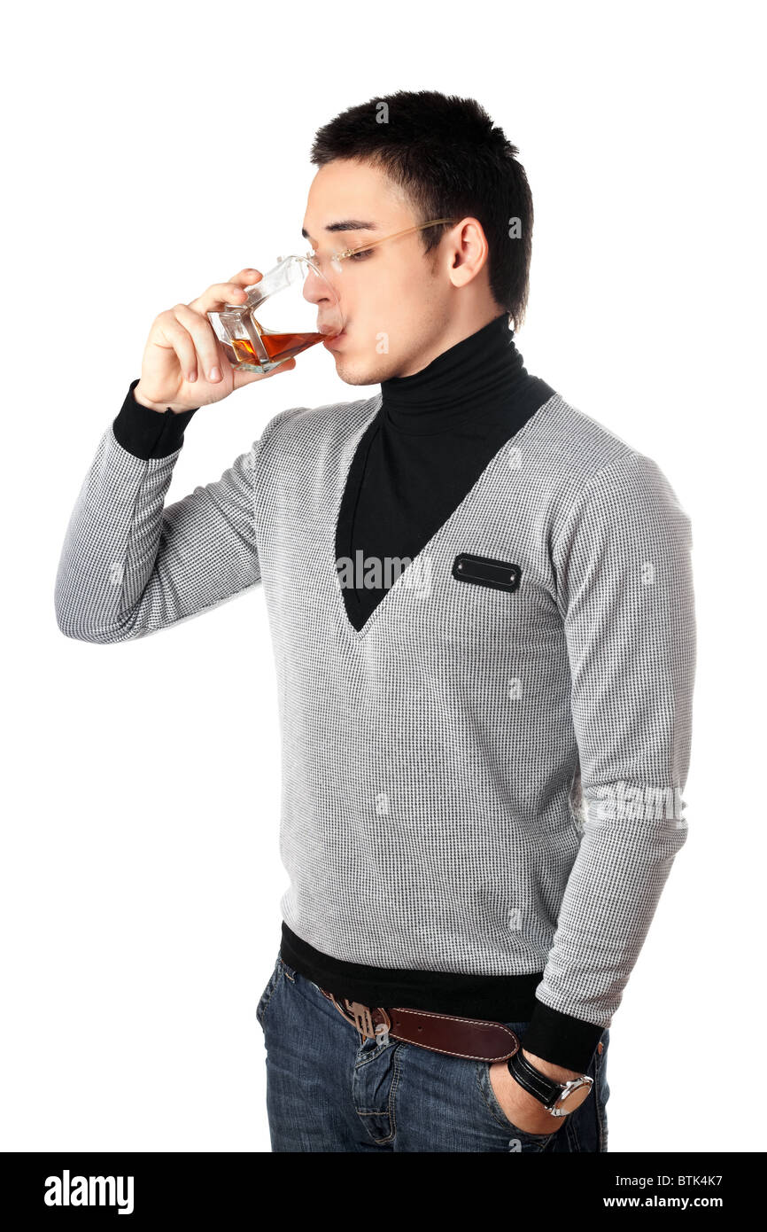 Junger Mann trinken Whisky aus einem Glas Stockfoto