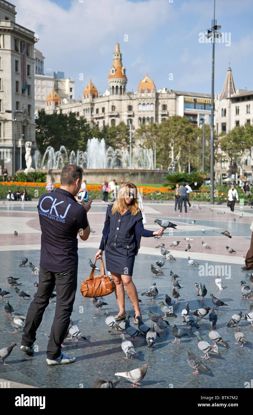 Paar die Tauben füttern. Plaça Catalunya. Barcelona. Spanien Stockfoto