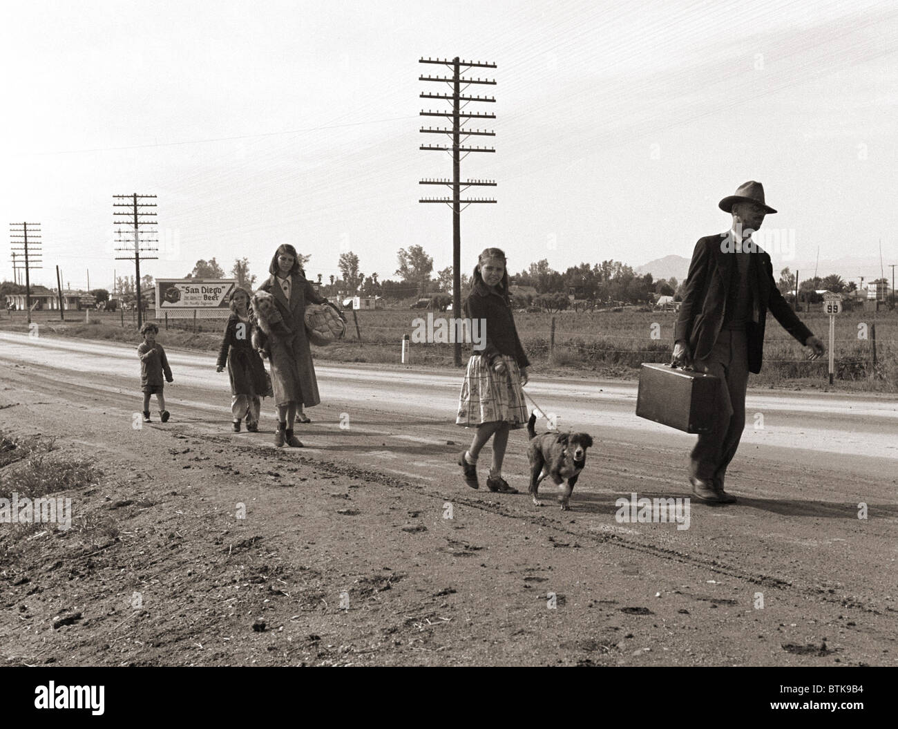 Obdachlose Migrantenfamilie von sieben, zu Fuß von der Autobahn aus Phoenix, Arizona, wo sie Baumwolle gepflückt. Sie gehen nach San Diego, wo der Vater hofft auf Erleichterung zu bekommen, weil er einmal dort gelebt. 1939-Foto von Dorothea Lange. Stockfoto