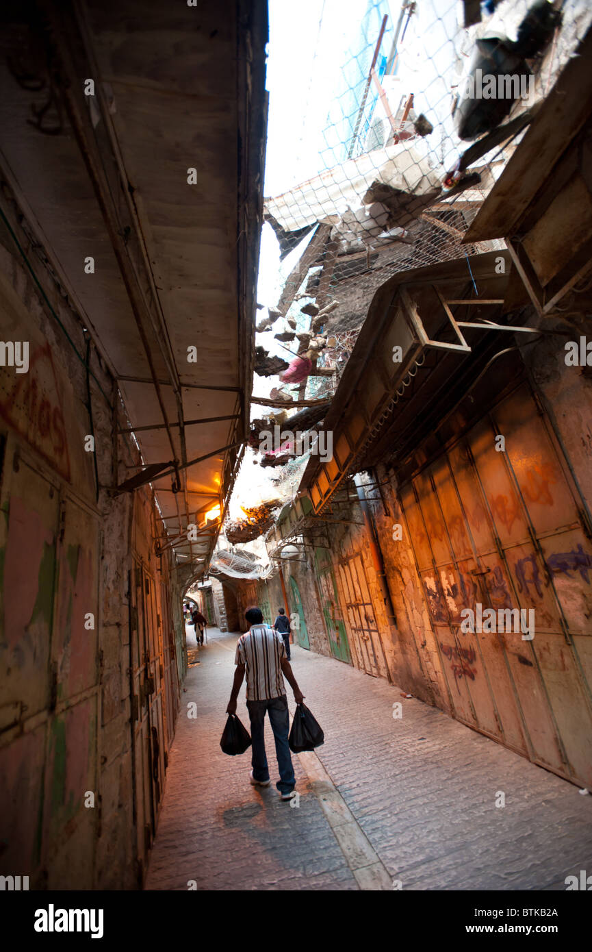 Netze über den Straßen von Hebron schützen palästinensischen Fußgänger aus dem Papierkorb geworfen durch israelische Siedler Leben über. Stockfoto