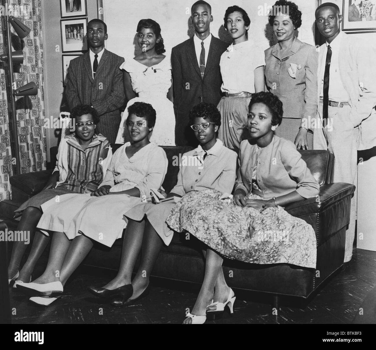 Little Rock Nine und Daisy Bates stellte im Wohnzimmer während der Wirren des staatlich erzwungene Desegregation der Central High School. Untere Reihe, von links nach rechts: Thelma Mothershed, Minnijean Brown, Elizabeth Eckford, Gloria Ray; Obere Reihe, von links nach rechts: Thomas Jefferson, Melba Pattillo, Terrence Roberts, Carlotta Wände, Daisy Bates (NAACP Präsident), Ernest Green. Ca. 1957. Stockfoto