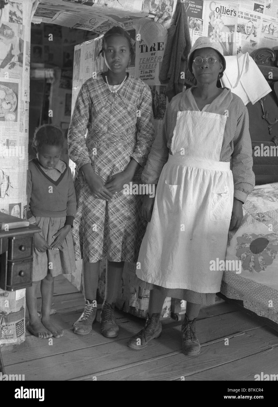 African American Mutter mit ihren beiden Töchtern lebt in primitiven Bedingungen als Plantage Mieter in Gees Bend, Alabama. Sie sind Nachkommen der Sklaven, die das gleiche Land vor dem Bürgerkrieg arbeitete. April 1937 Foto von Arthur Rothstein. Stockfoto