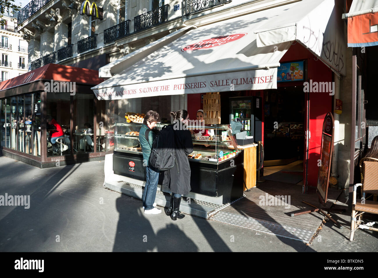 zwei Paris Frauen wählen Sie Gebäck aus Zähler von hübschen Asiatin außerhalb Teeladen am Boulevard Saint Michel Paris gepflegt Stockfoto