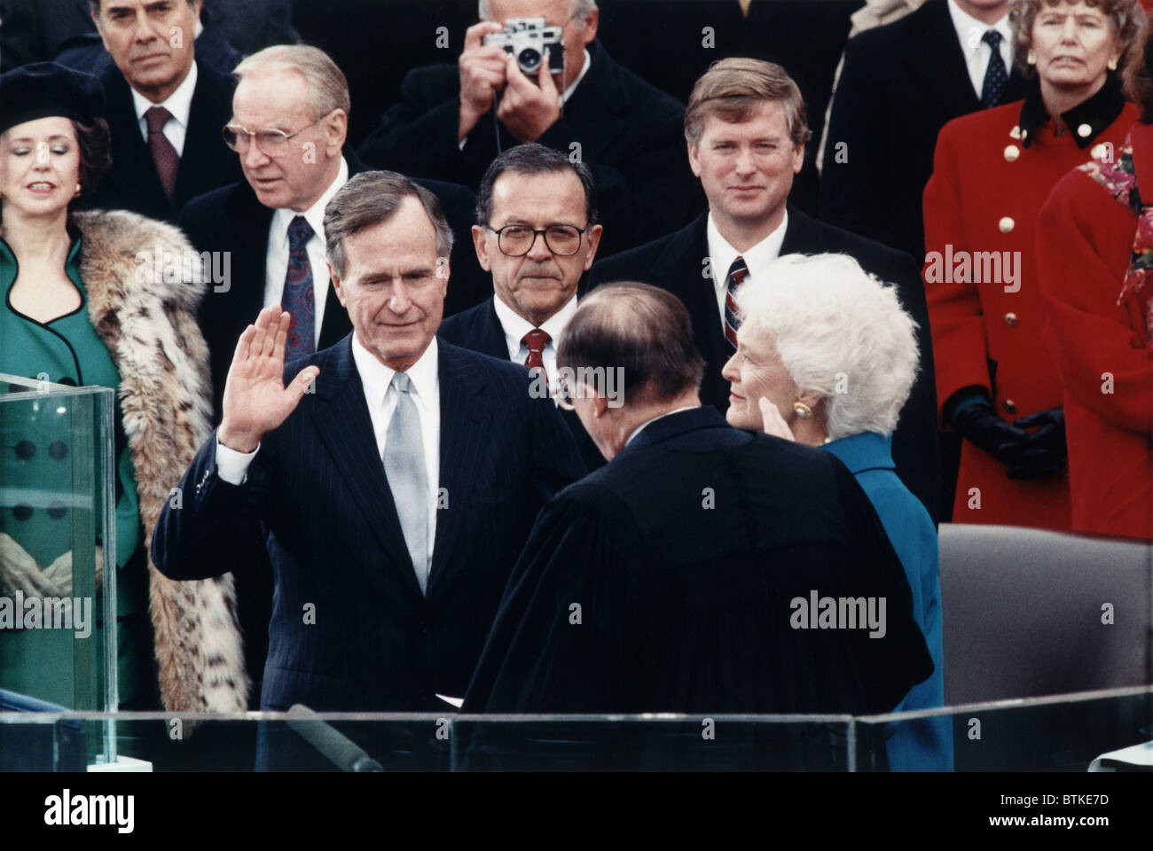 Präsident George Herbert Walker Bush nimmt den Amtseid von Oberrichter William Rehnquist verwaltet. Vizepräsident Dan Quayle und Barbara Bush blicken auf. 20. Januar 1989. Stockfoto
